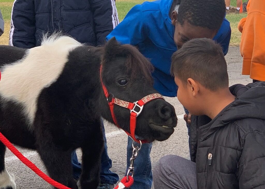 Angel greeting two boys at a school visit